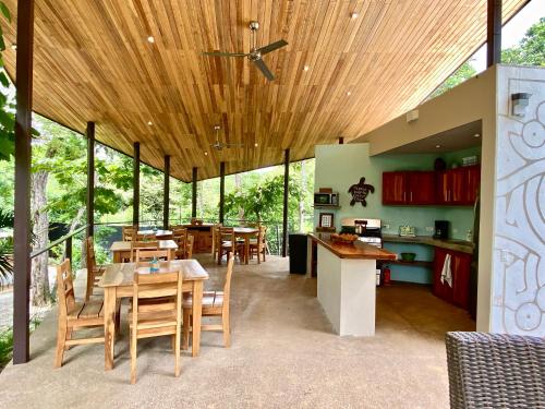 a kitchen and dining room with a wooden ceiling at Villas Kalei in Playa Grande