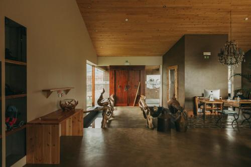 a living room with a wooden door and a table at Santa Barbara Eco-Beach Resort in Ribeira Grande