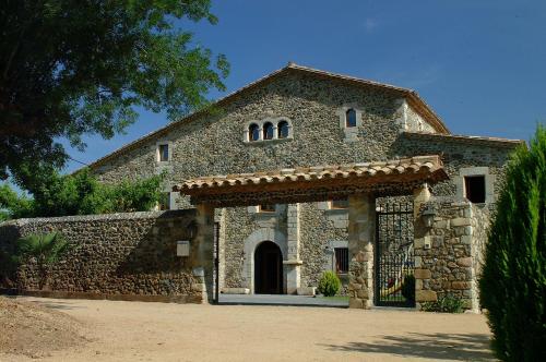 uma antiga casa de pedra com uma parede de pedra em Mas la Casassa em Sant Gregori
