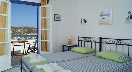 1 dormitorio con 1 cama y balcón con vistas. en Sevasti Rooms, en Platis Yialos Sifnos