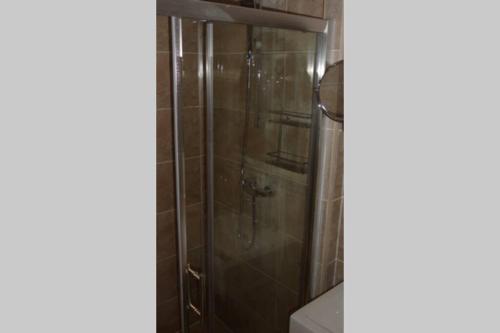 La salle de bains est pourvue d'une douche avec une porte en verre. dans l'établissement St Nicholas, à La Valette