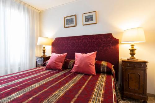 a bedroom with a large bed with pink pillows at Palazzo Schiavoni Suite-Apartments in Venice