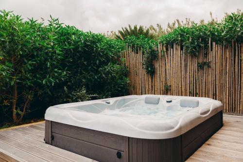 a bath tub sitting on a wooden deck at Santa Barbara Eco-Beach Resort in Ribeira Grande