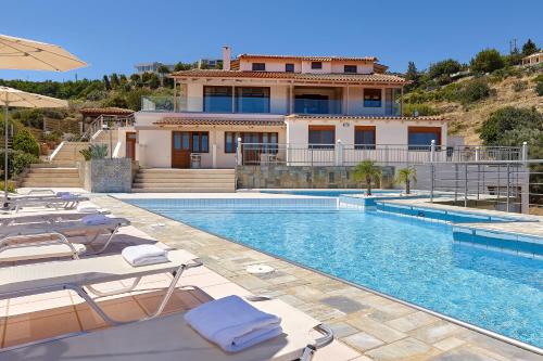 uma villa com piscina em frente a uma casa em Keramos Villa & Apartments em Agia Pelagia