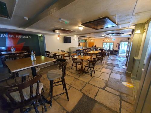 um restaurante com mesas e cadeiras num quarto em The Lugger Inn em Weymouth