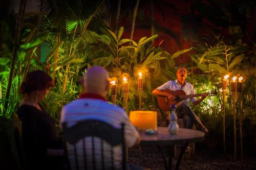 
a man sitting at a table with a candle lit at Hotel Vogue in Sayulita
