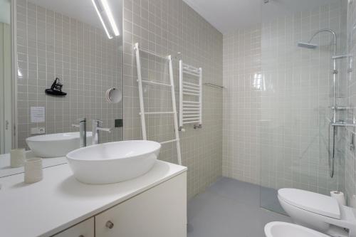 - Baño blanco con 2 lavabos y ducha en Miguel Bombarda - Porto Houses & Suites, en Oporto