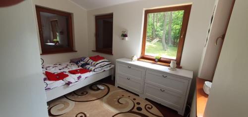 a small bedroom with a bed and a window at Wooden House&Pool in Osowa