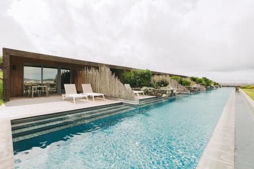 a house with a swimming pool next to a house at Santa Barbara Eco-Beach Resort in Ribeira Grande
