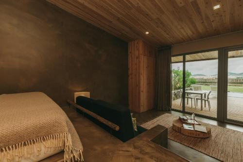 a bedroom with a bed and a large window at Santa Barbara Eco-Beach Resort in Ribeira Grande