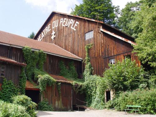 a barn covered in ivy with a sign on it at Les Sapins in Bussang