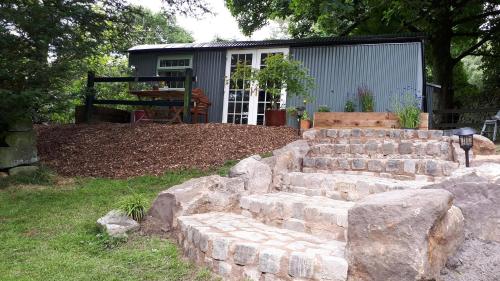 a set of stone steps in a yard with a building at The Owl Hoot in Ipstones