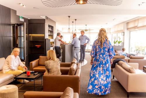 un groupe de personnes debout dans un salon dans l'établissement Hotel Nelson, à Knokke-Heist