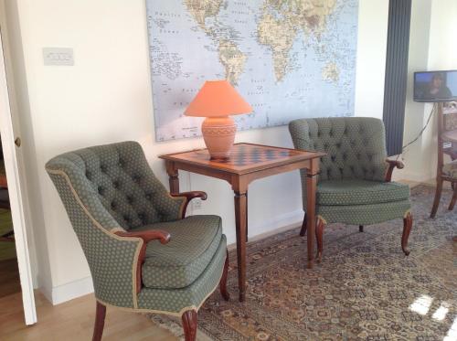 twee stoelen en een tafel met een lamp erop bij Redroofs in Tenbury