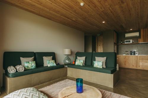 a living room with a green couch and a table at Santa Barbara Eco-Beach Resort in Ribeira Grande