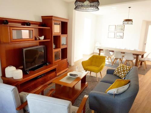 sala de estar con sofá, TV y mesa en Casa D`Avó Joana, en Ponta Delgada