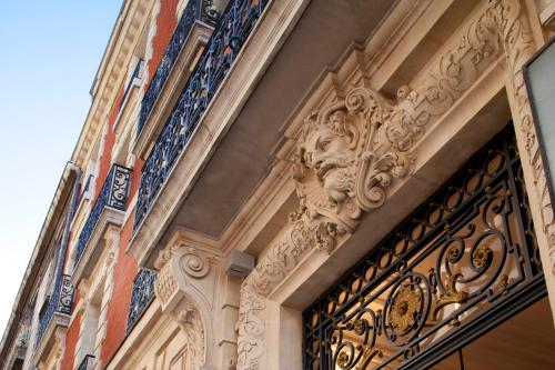 an ornate iron gate on the side of a building at Hôtel Oceania Le Métropole in Montpellier