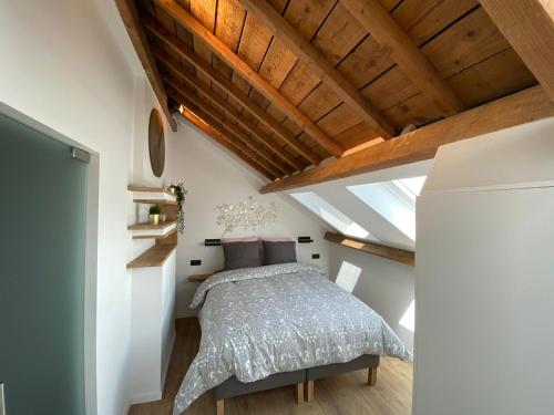 a bedroom with a bed and a wooden ceiling at NEW Urban Studio Libramont in Bonance