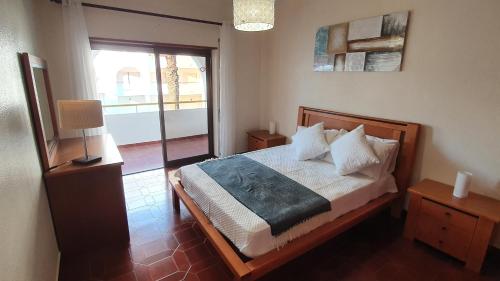 a bedroom with a bed and a large window at Casa Angela, 180m from the beach in Porches