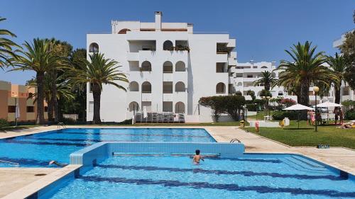 a person in a swimming pool in front of a building at Casa Angela, 180m from the beach in Porches