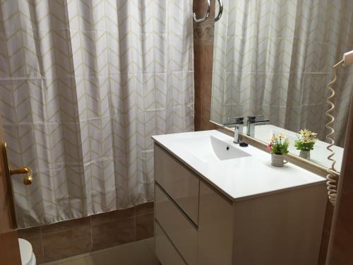 a bathroom with a sink and a shower curtain at Mediterranea in La Pineda