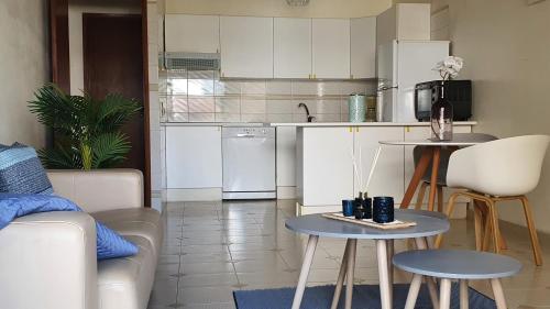 a kitchen with a couch and tables in a room at Casa Angela, 180m from the beach in Porches