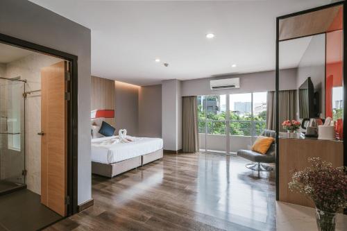 a bedroom with a bed and a chair in a room at Season Place in Bangkok