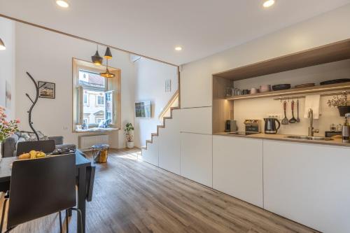 cocina y sala de estar con armarios blancos y mesa en Old Quarter Residence en Liubliana