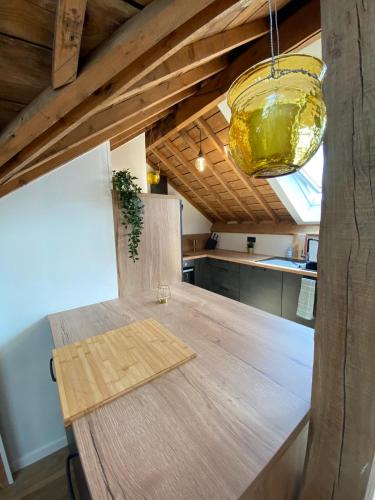 a kitchen with a wooden table with a light fixture at NEW Urban Studio Libramont in Bonance