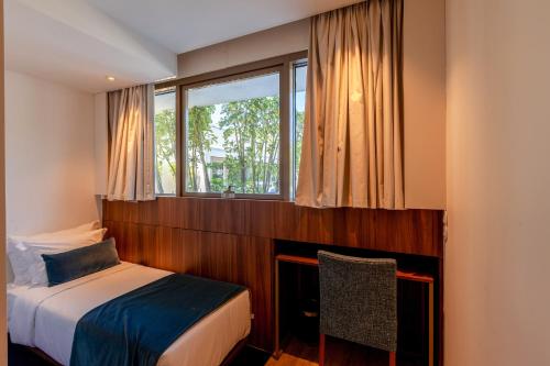 a bedroom with a bed and a window at Sea Porto Hotel in Matosinhos