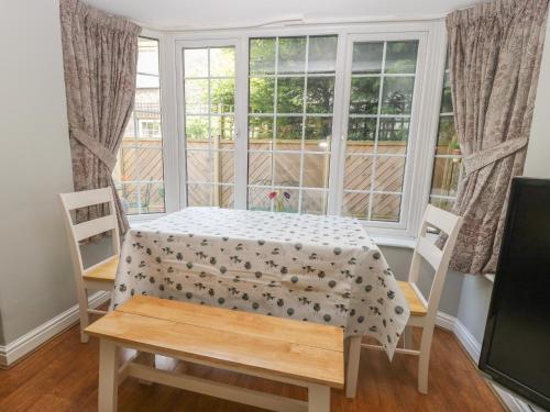 a table and chairs in a room with a window at Wedgewood Cottage in Leyburn