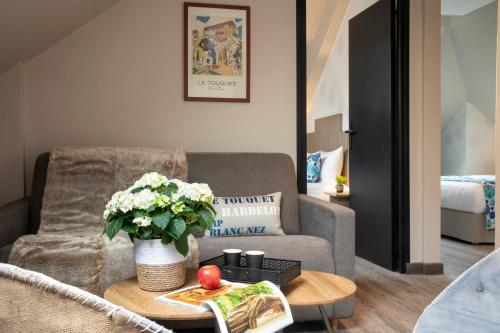 a living room with a couch and a table at Cocoon inn in Cucq