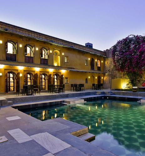 a large swimming pool in front of a building at Gogunda Palace in Udaipur