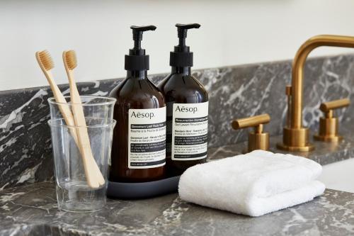 two bottles of soap and towels on a bathroom counter at San Luis Creek Lodge in San Luis Obispo