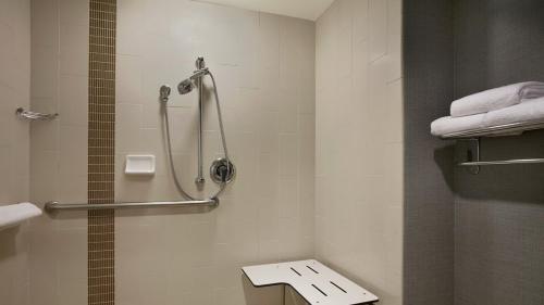 a bathroom with a shower and a toilet with towels at Hyatt Place Salt Lake City/Cottonwood in Cottonwood Heights