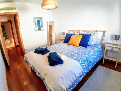 a bedroom with a bed with blue and orange pillows at Cardeal´s Nest in Lisbon