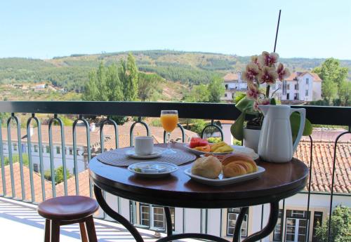 a table with food and drinks on a balcony at A Moderna - Guest house Casa dos Serpas in Caldas da Felgueira