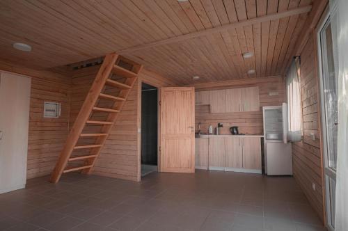 une cuisine avec un plafond en bois et une échelle. dans l'établissement Vėjo Malūnų sodyba, à Paserninkai
