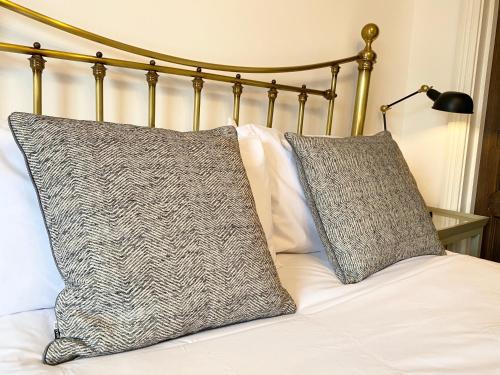 a bed with two pillows on top of it at Stylish Apartments in Pimlico & Westminster in London