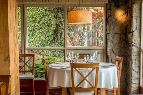 a table in a room with a large window at Mirador del Lago Hotel in El Calafate