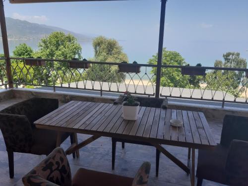 uma mesa de madeira com um vaso de plantas numa varanda em Nice apartment with terrace and like view . em Pogradec