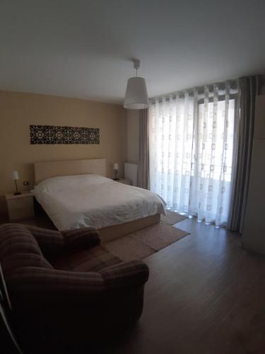 um quarto com uma cama e um sofá em Nice apartment with terrace and like view . em Pogradec