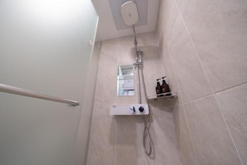 a shower in a bathroom with a shower head at Seoul N Guesthouse Dongdaemoon in Seoul
