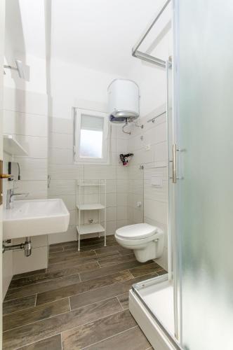 a bathroom with a toilet and a sink and a shower at Guest house Levanda in Split