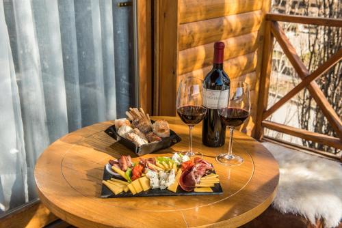 a table with a plate of food and two glasses of wine at Mirador del Lago Hotel in El Calafate