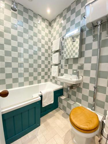 a bathroom with a wooden toilet and a sink at Stylish Apartments in Pimlico & Westminster in London