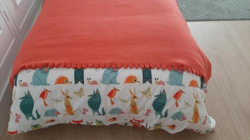 a bed with a red sheet with birds on it at O VIOLAS - Art Coffee & Guesthouse in Praia de Mira