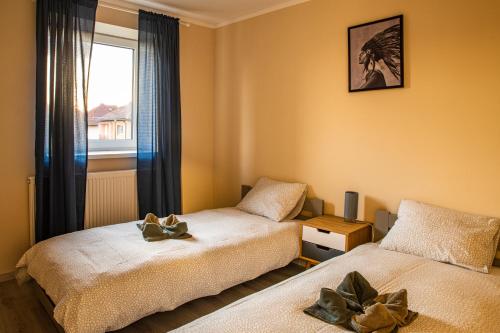 two beds in a room with a window at K-house in Liptovský Mikuláš