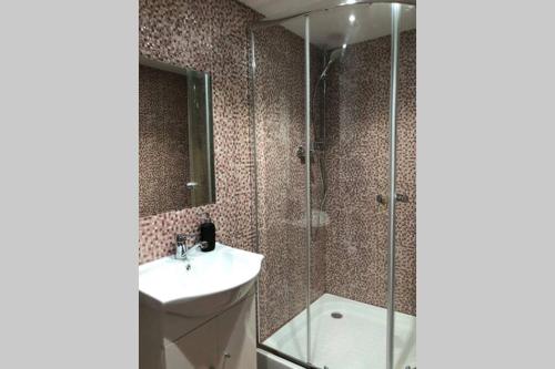 a bathroom with a shower and a sink and a mirror at Hunter's Lodge in (( Šarlote ))