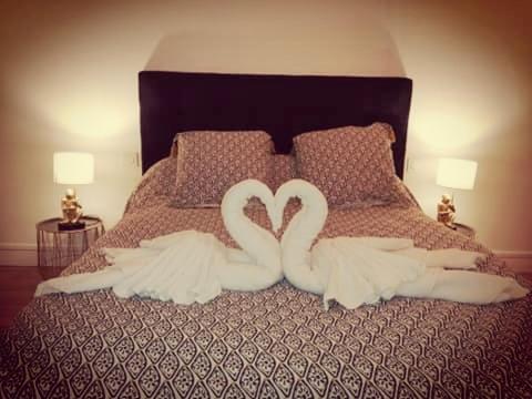 two white swans making a heart on a bed at maison de campagne in La Celle-Saint-Cyr
